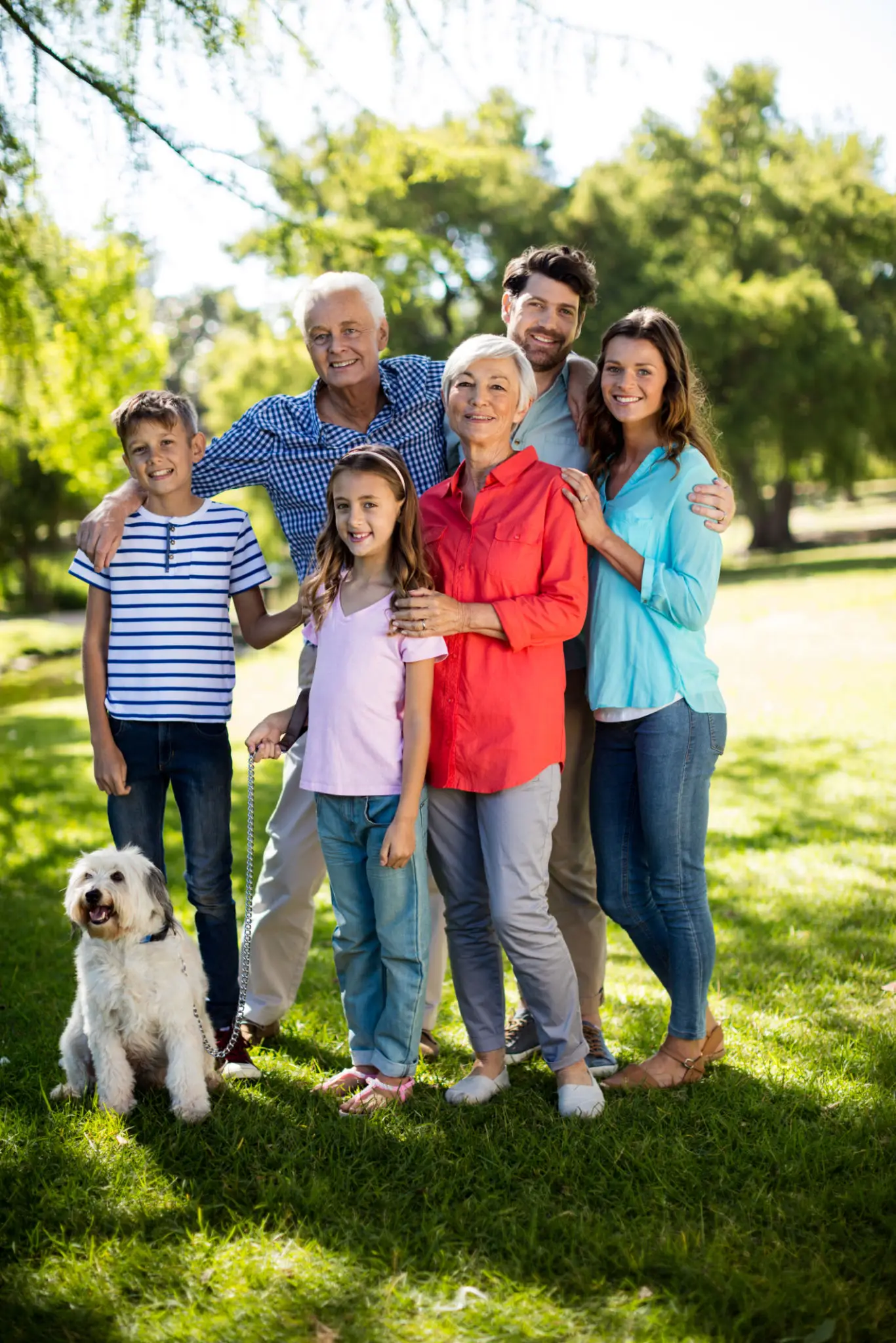 Family portrait with dog in sunny park.